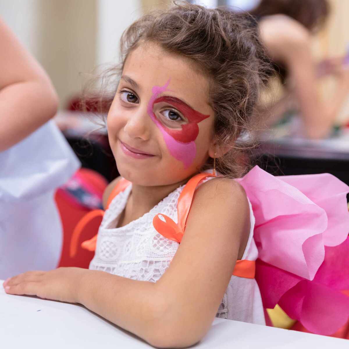 Primo piano di bambina con trucco teatrale applicato al viso