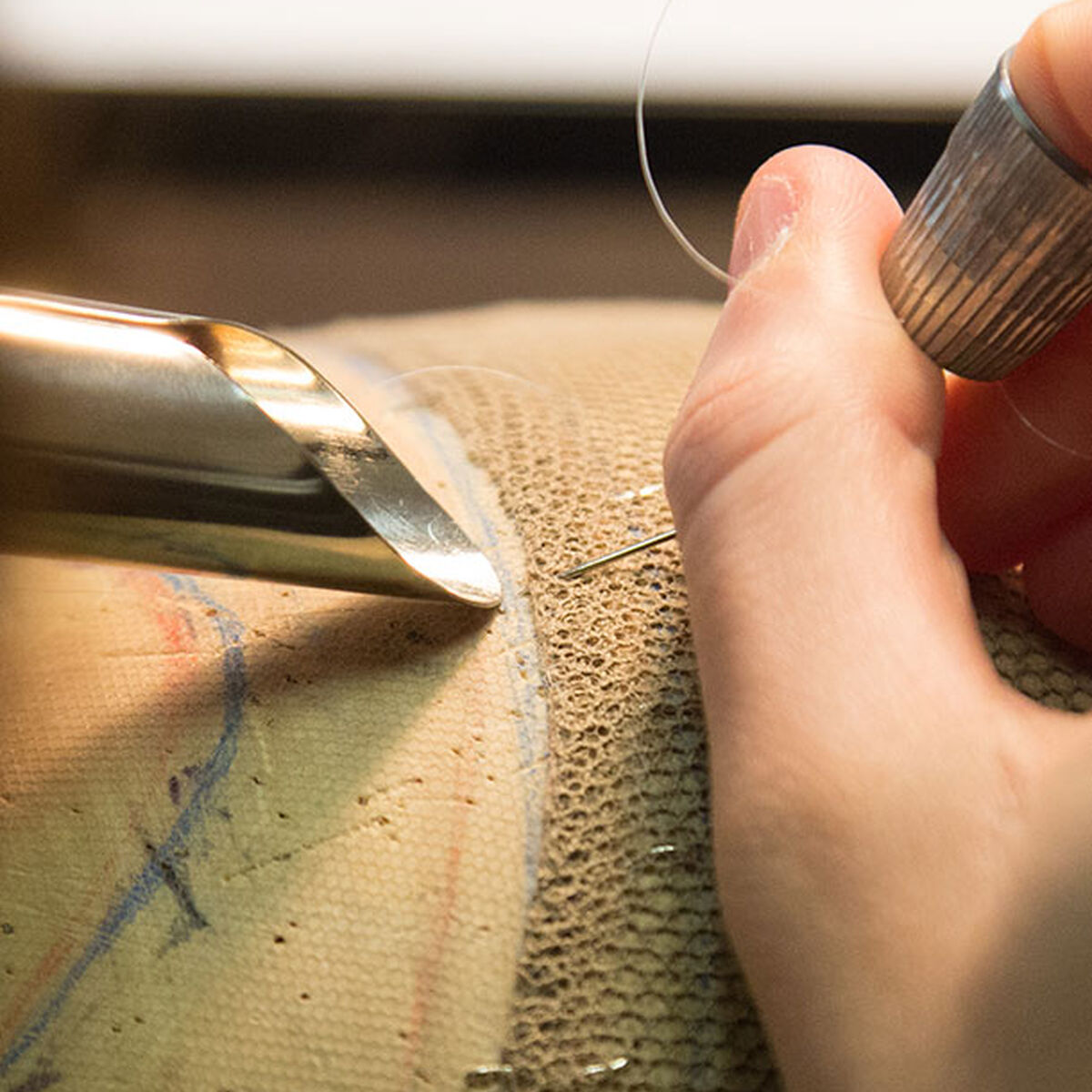 dettaglio del lavoro del parruccaio su retina di tulle