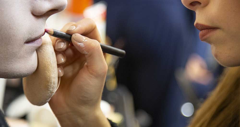 presentazione corso make-up, truccatrice al lavoro su labbra
