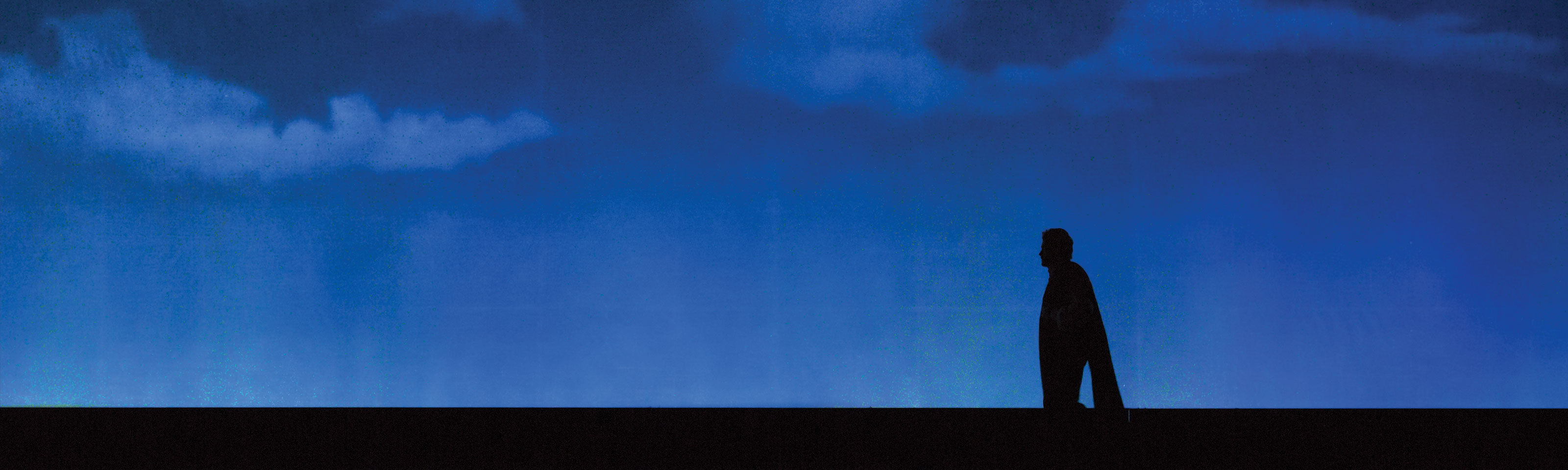 black silhouette on a dark blu light