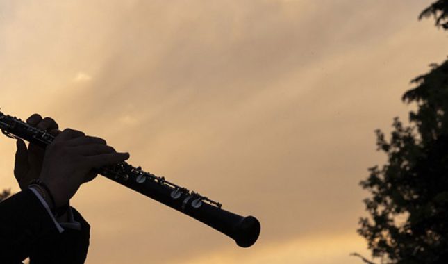 un musicista suona l'oboe all'arco della pace di milano